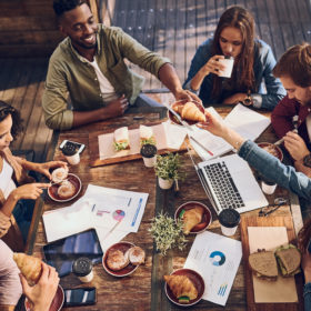Shot of a group of creative workers having a meeting over lunch in a cafe